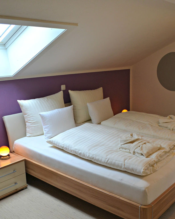 Schlafzimmer von Appartement mit klassischem Holz-Doppelbett und dekorativen Kreisen an der Wand