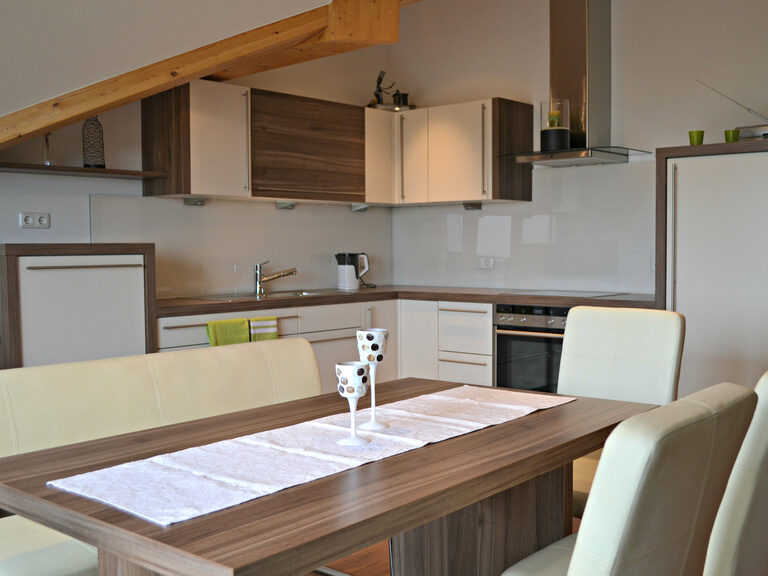 Luxuriöse Küche mit dekorativem Esstisch und Lederstühlen im Premium-Appartement