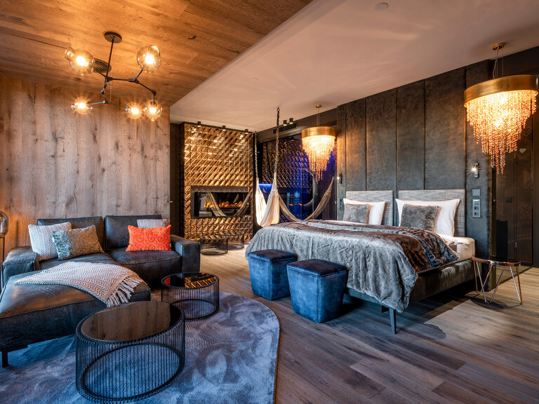 Moderne Luxus-Suite mit großem Bett, Hängematte, Kronleuchtern im Hüttenhof