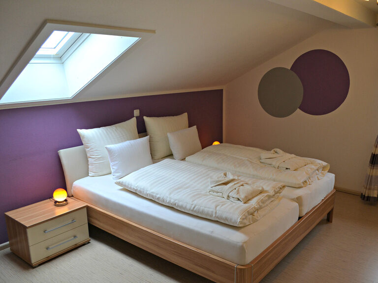 Schlafzimmer in Appartement mit klassischem Holz-Doppelbett und dekorativen Kreisen an der Wand