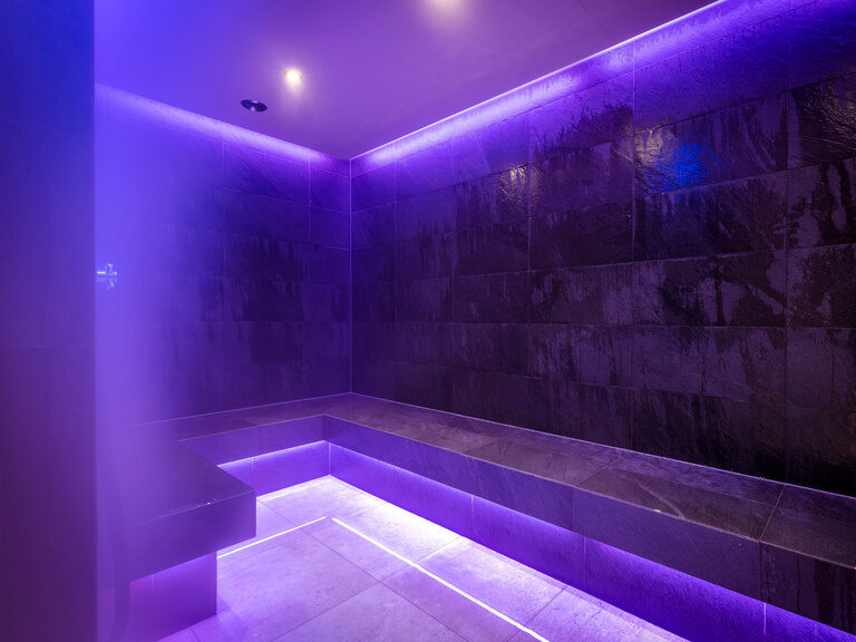 Moderner Raum mit Sitzbank für Aroma Dampfbad mit violettfarbener Beleuchtung