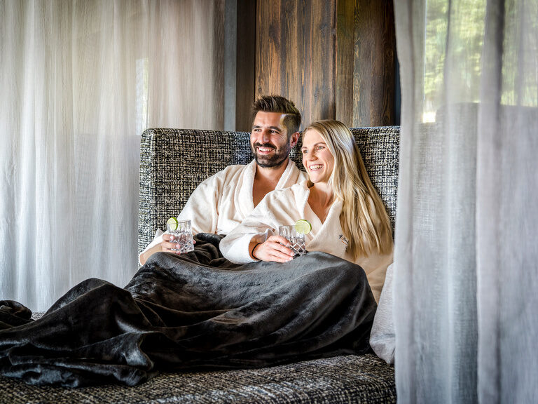 Aroma Dampfbad mit Beleuchtung im Wellnesshotel Hüttenhof Modern gestalteter Raum mit Sitzbank für Aroma-Dampfbad, beleuchtet in warmen Rottönen