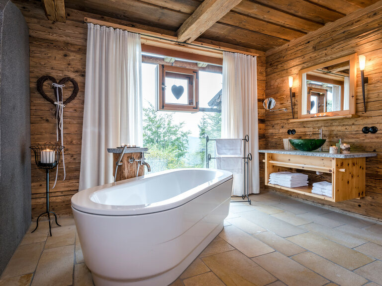 Freistehende Badewanne mit großem Fenster im Luxus Chalet Bayern Freistehende Badewanne mit großem Fenster im Luxus Chalet Bayern