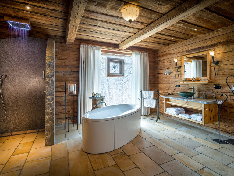 Badezimmer im Chalet Ein großes Badezimmer im Chalet mit Regendusche und freistehender Badewanne