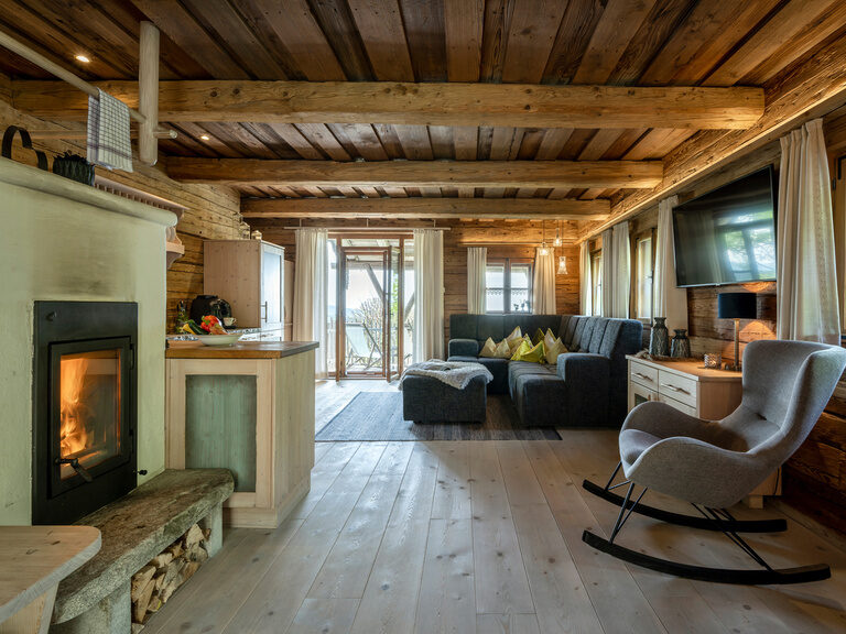 Stube im Luxus-Chalet mit Schaukelstuhl, Kamin, Couch und Küche
