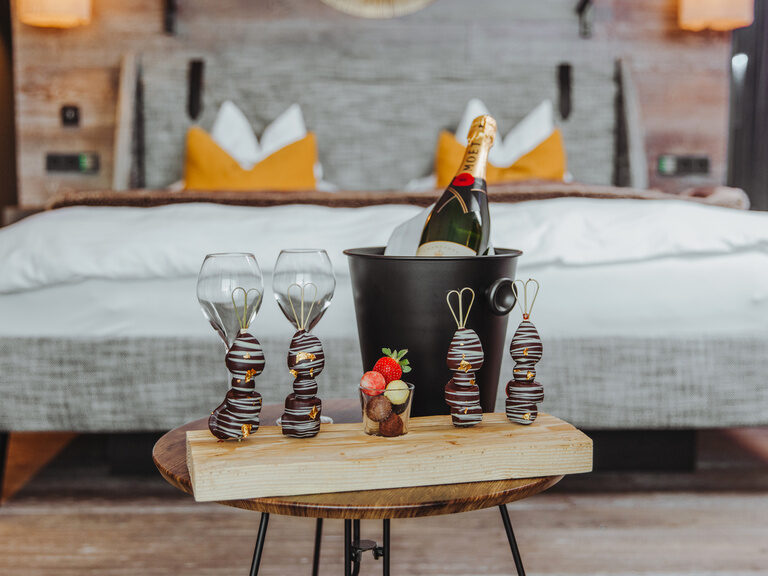 Romantisch dekoriertes, Luxus-Zimmer mit Kamin und Badewanne, Herz aus Rosenblättern auf Bett