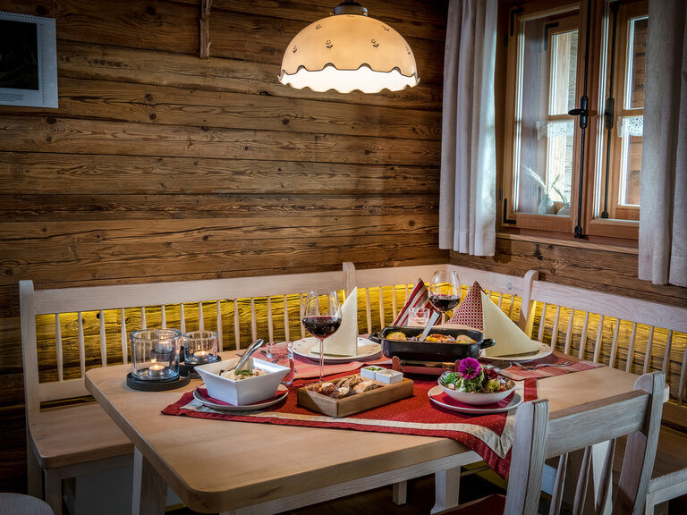 Genießen Sie den besonderen Service im Luxus-Chalet Gedeckter Tisch mit Reindlbraten, Eckbank im Luxus-Chalet