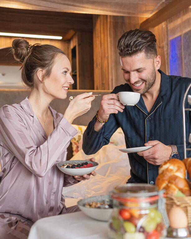 Pärchen im Schlafanzug beim Frühstücken im Bett des 4 Sterne Wellnesshotel Hüttenhof im Bayerischen Wald