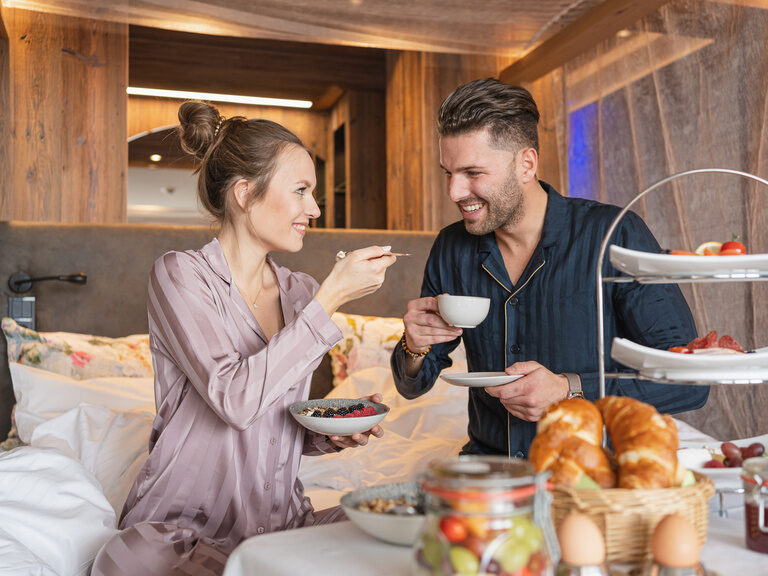 Im Bett sitzendes Pärchen beim Frühstücken des 4 Sterne Wellnesshotel in Bayern