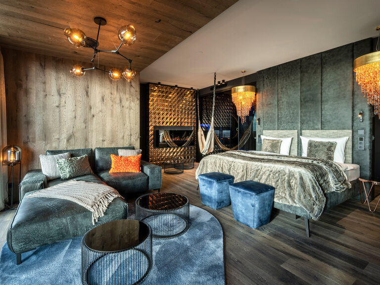 Moderne Luxussuite mit Kamin, Hängematte, Couch, Kronleuchter im Wellnesshotel Hüttenhof