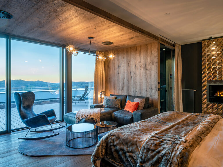 Blick auf Panorama mit Dämmerung des Balkons in Luxuszimmer mit Sofa und Kamin