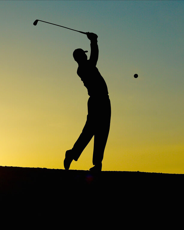 Schatten von Golfspieler beim Abschlag in Dämmerung