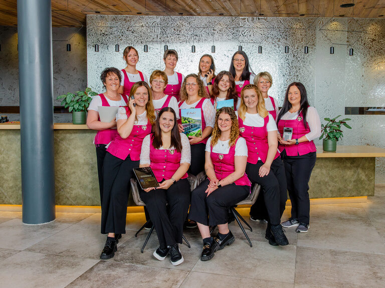 Rezeptionsteam 4-Sterne-Luxushotel Hüttenhof Rezeptionsteam in pinker Trachtenweste im Luxus-Wellnesshotel Hüttenhof