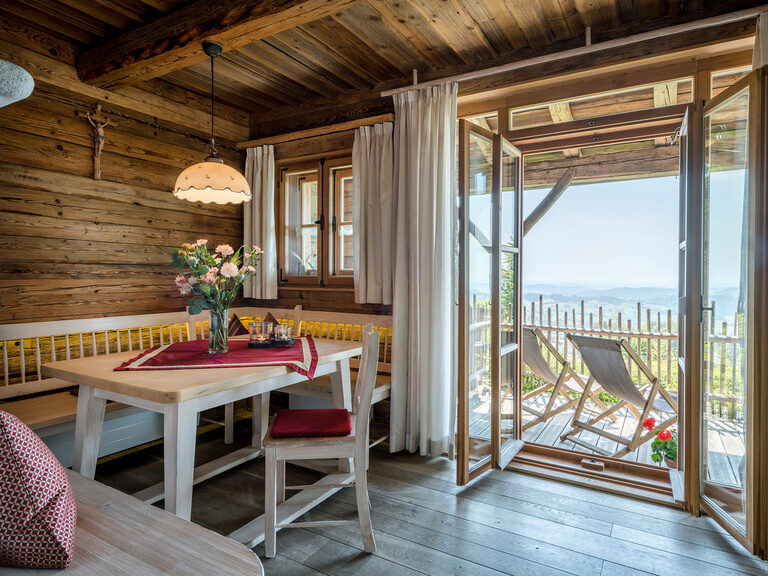Modernes Hotelzimmer mit offener Badewanne und Balkon im Wellnesshotel Hüttenhof Modernes Hotelzimmer mit offener Badewanne, Sessel mit Beistelltisch und Balkon