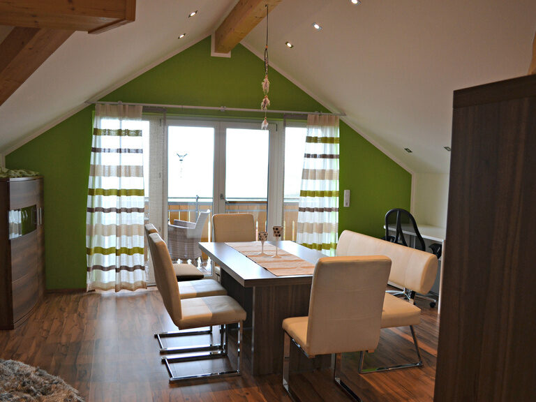 Esszimmer mit Balkon, Esstisch mit Lederstühlen im Wellnesshotel Hüttenhof Modernes Esszimmer mit Balkon, Holz-Esstisch und hellen Lederstühlen