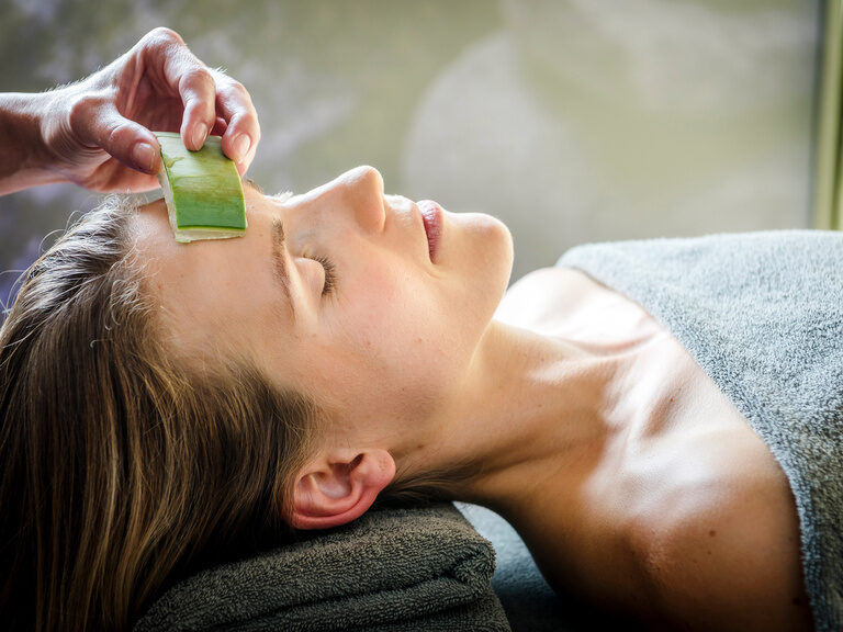 Nahaufnahme von Frau bei Beauty-Behandlung mit Gesichtstool auf Behandlungsliege