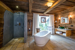 Freistehende Badewanne mit großem Fenster im Bergdorf Hüttenhof Freistehende Badewanne mit großem Fenster im Bergdorf Hüttenhof