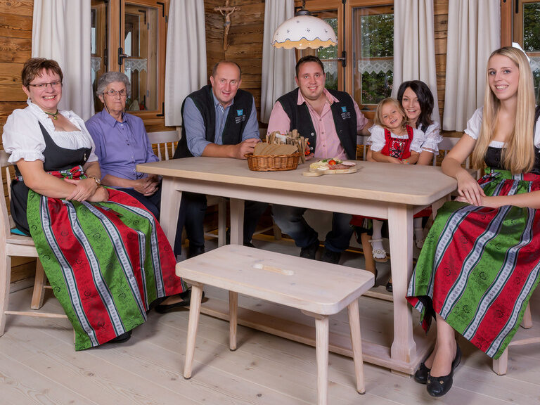 Gastgeber in Tracht sitzen am Tisch im Hotel Hüttenhof