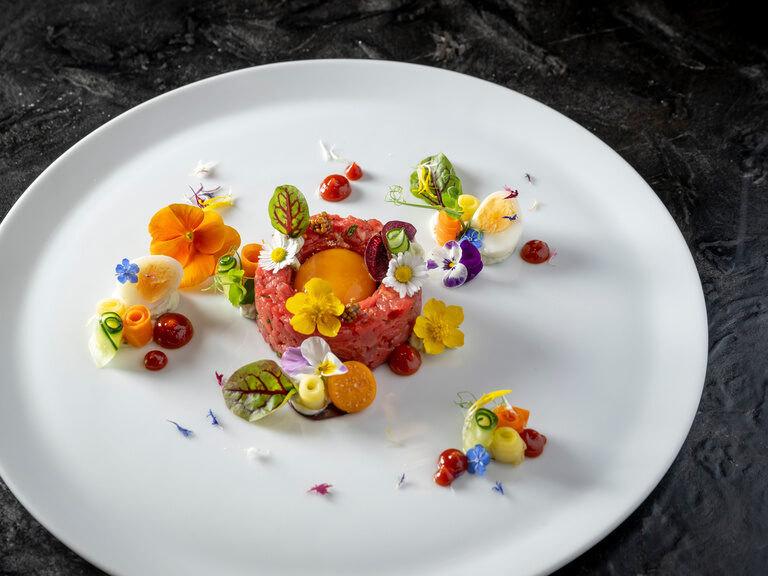 Wellenförmiger Teller mit Calamari und Frühlingsrollen im 4-Sterne-Hotel Hüttenhof