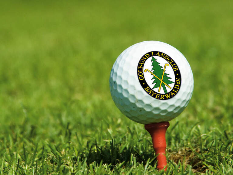 Golfball auf grünem sonnigem Rasen auf Golfplatz