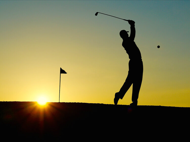 Golfspieler beim Abschlag in Dämmerung im Bayerischen Wald Schatten von Golfspieler beim Abschlag in Dämmerung