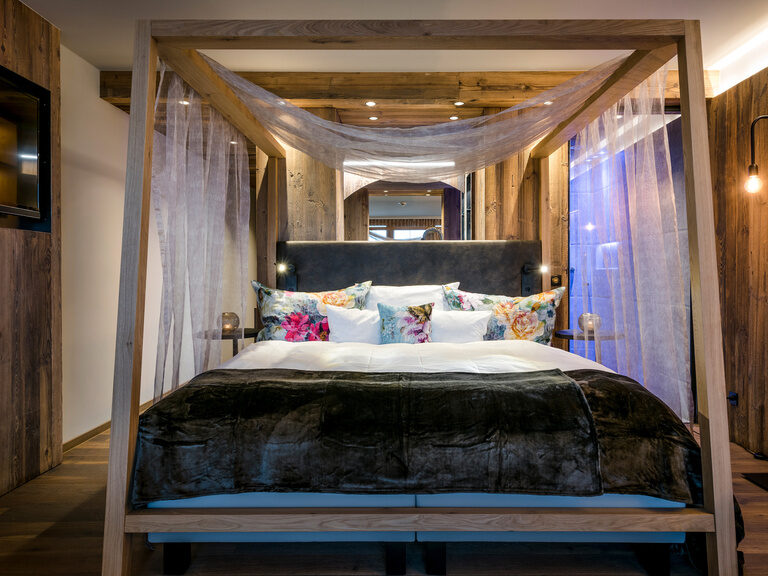 Modernes Hotelzimmer mit Himmelbett und Whirlpool im Zimmer Modernes Hotelzimmer mit Himmelbett und Whirlpool im Zimmer - Romantiksuite mit privater Sauna und Pool