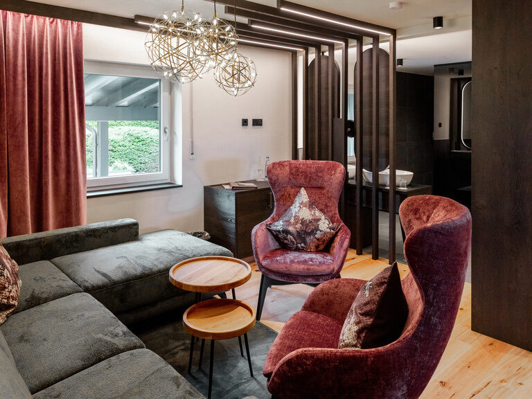 Kleiderbügel mit Jackett wird auf Kleiderstange gehängt, im Hintergrund lachende Frau