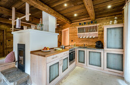 Küche mit Kachelofen im Luxus Chalet Bayern im Bergdorf Hüttenhof Küche mit Kachelofen im Luxus Chalet Bayern im Bergdorf Hüttenhof