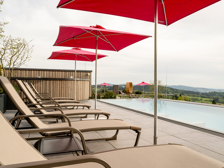 Küssendes Paar sitzt im Schlafanzug mit einem Glas Sekt im gemütlichen Bett des 4 Sterne Wellnesshotel Hüttenhof in Niederbayern Küssendes Paar sitzt im Schlafanzug mit einem Glas Sekt im gemütlichen Bett des 4 Sterne Wellnesshotel Hüttenhof im Bayerischen Wald