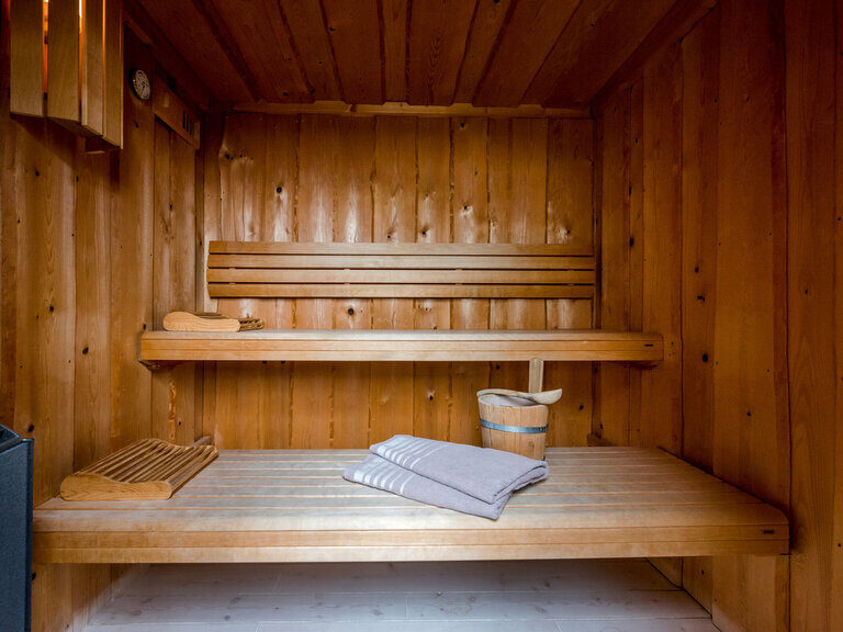 Lächelndes Paar genießt Panorama im Außenpool vom 4-Sterne-Luxushotel Hüttenhof