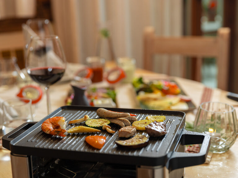 Lächelndes Paar im Außenpool vom 4-Sterne-Wellnesshotel Hüttenhof Lächelndes Paar genießt Panorama im Außenpool vom 4-Sterne-Luxushotel Hüttenhof