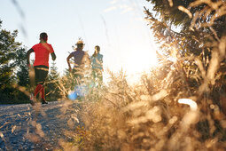 Freizeit und Wandern am Hotel Hüttenhof Grainet Drei Läufer im Sonnenaufgang laufen auf einen Berg