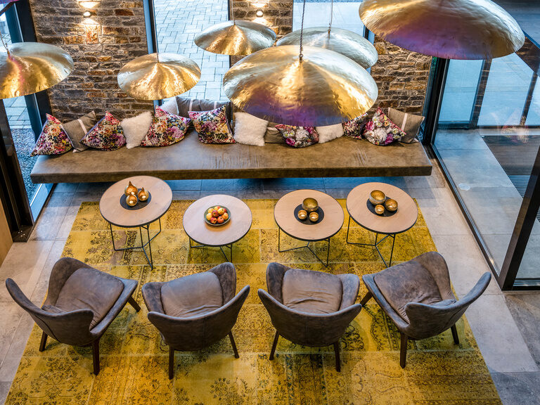 Lobby mit Tischchen, Stühlen und Couch im Hotel Hüttenhof