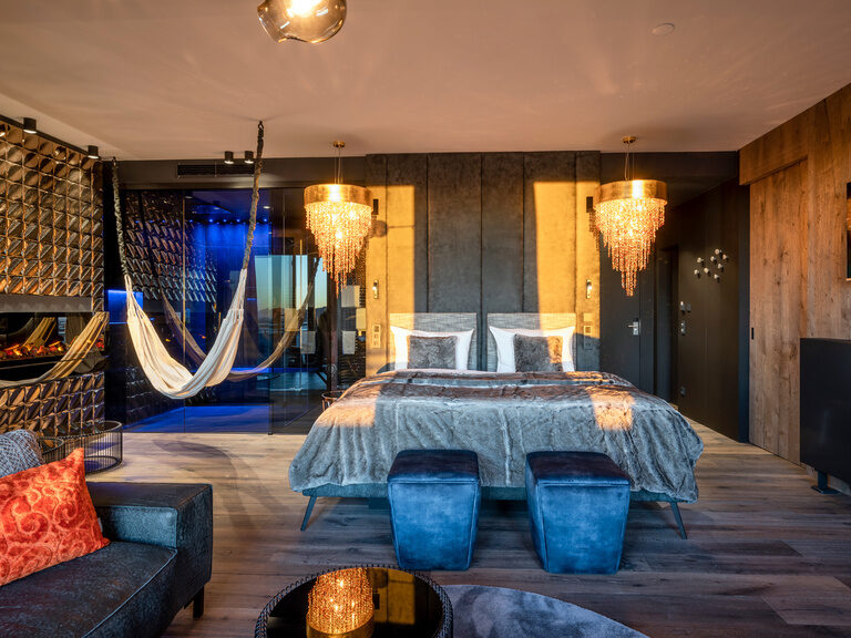 Moderne Luxussuite mit goldenem Kamin, Couch, Kronleuchter im Wellnesshotel Hüttenhof