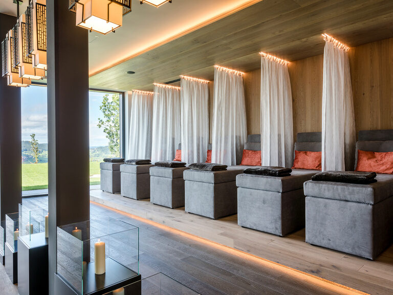 Moderner Ruheraum, in stimmungsvoller Beleuchtung mit Liegen und Trennvorhängen