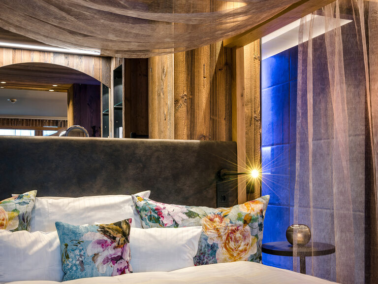 Detaillierte Ansicht von modernem Himmelbett mit dekorativen Kissen in Blumenmuster