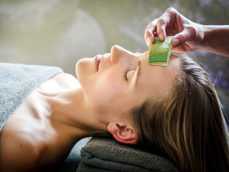 Nahaufnahme von Frau mit geschlossenen Augen auf Liege bei Beauty-Behandlung mit Aloe vera