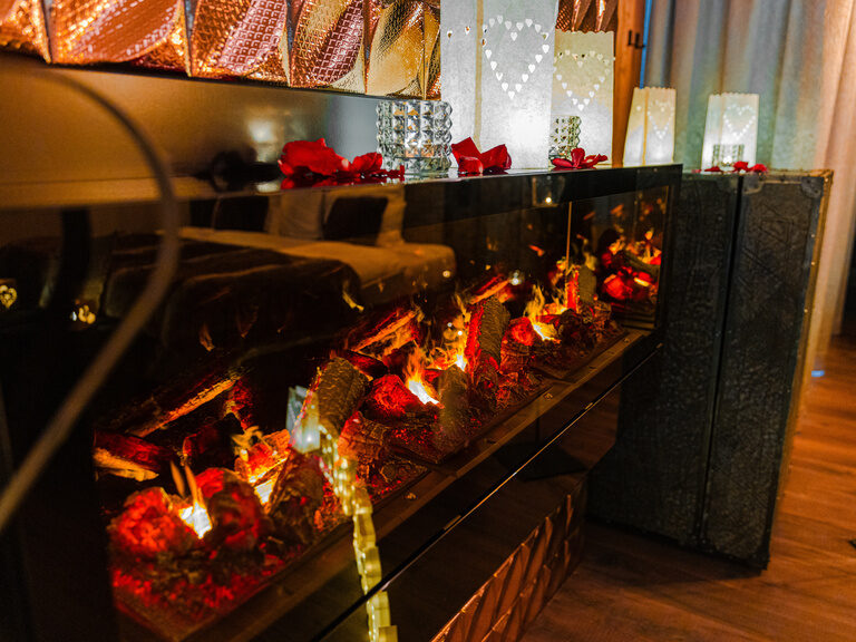 Glückliches Paar stößt in der Lounge mit Sektgläsern an, während sie sich liebevoll anblicken