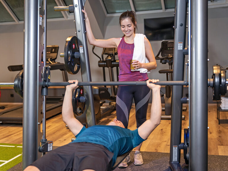 Rückenansicht von Paar im Bademantel, das Sonne auf Terrasse vom Hotel genießt