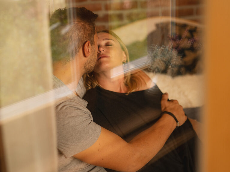 Paar liegt auf Sofa im 4-Sterne-Luxushotel Hüttenhof Paar liegt Arm in Arm auf einem Sofa im 4-Sterne-Wellnesshotel Hüttenhof