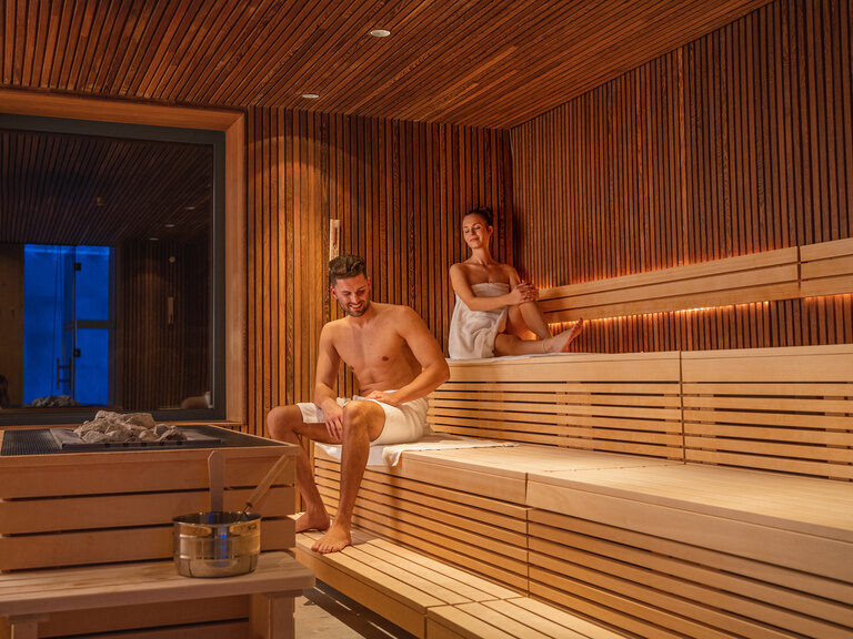 Paar entspannt sich in moderner Holz-Sauna im Luxushotel Hüttenhof