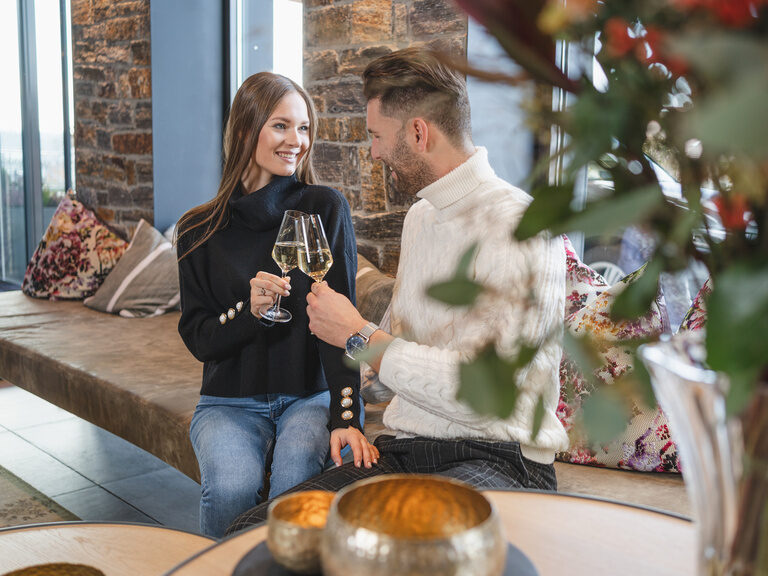 Pärchen beim Check-in mit Glas Prossecco Pärchen in der Lobby stoßt mit Prossecco auf den Urlaub an