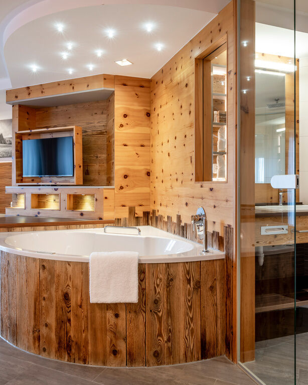 Privater Whirlpool am Zimmer mit Holzverkleidung und Fernseher