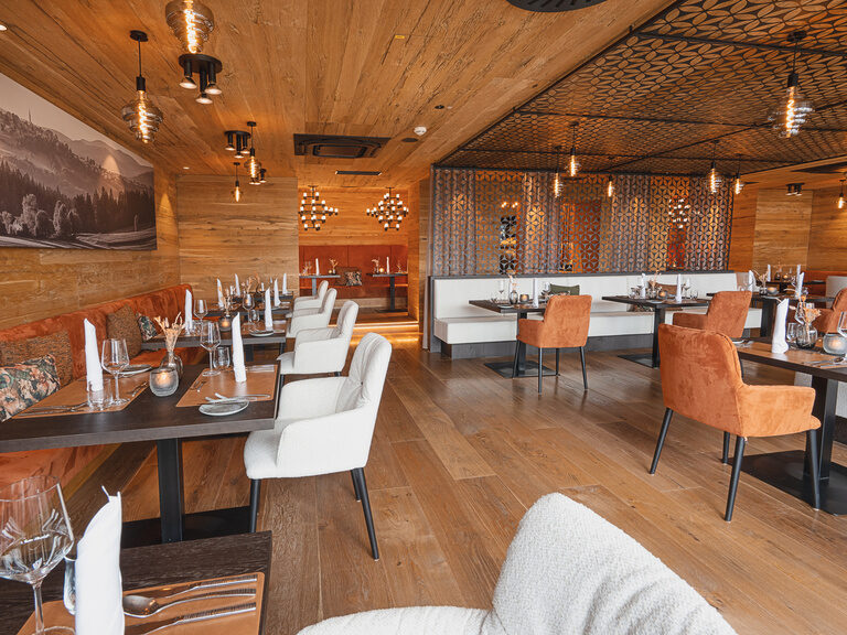 Panorama-Restaurant mit Wildleder-Sitzbank, schwarzen Kronleuchtern und Holzwand- und decke