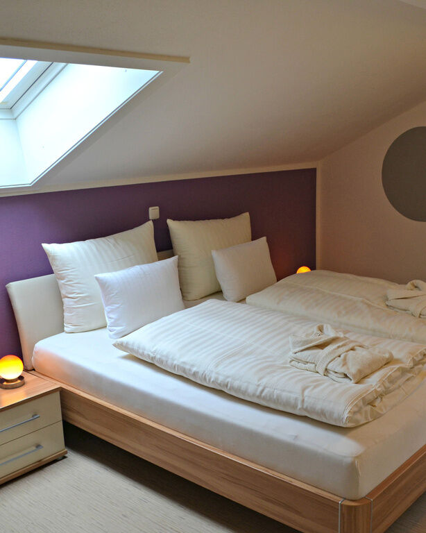 Schlafzimmer von Appartement mit klassischem Holz-Doppelbett und dekorativen Kreisen an der Wand