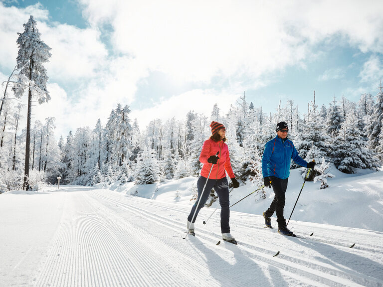 Schneeschuhwanderer im Bayerischen Wald im Winter Zwei Schneeschuhwanderer lachen und sitzen im Schnee im Bayerischen Wald