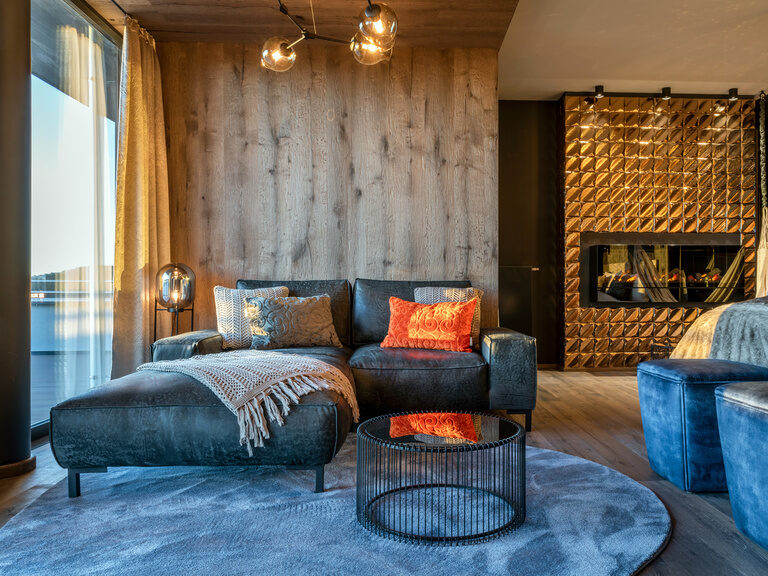 Sofa und goldener Kamin in Luxussuite mit Balkon im Hotel Hüttenhof
