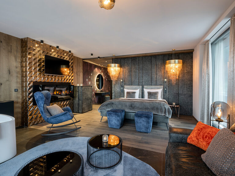 Moderne Suite, Geschmackvoll eingerichtet mit zwei Kronleuchtern, einem großen Bett und einem großen Effektkamin in der Wand