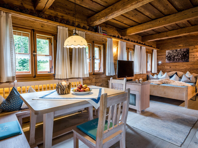 Teelicht in Herz-Holzbox, Rosenblätter und 'Ich liebe dich'-Lichtschrift an der Wand