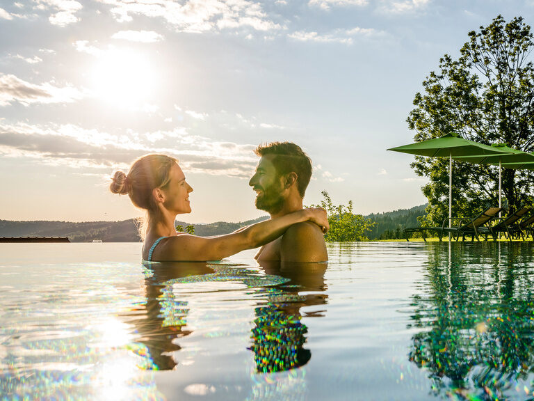 Verliebtes Pärchen schwelgt Arm in Arm des ganzjährig beheizten Infinity-Außenpools des 4 Sterne Luxushotel Hüttenhof in Niederbayern Verliebtes Pärchen schwelgt Arm in Arm im Infinity-Außenpool des 4 Sterne Luxushotel Hüttenhof im Bayerischen Wald